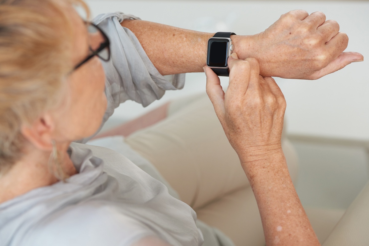Senior woman looking down at her smart watch.