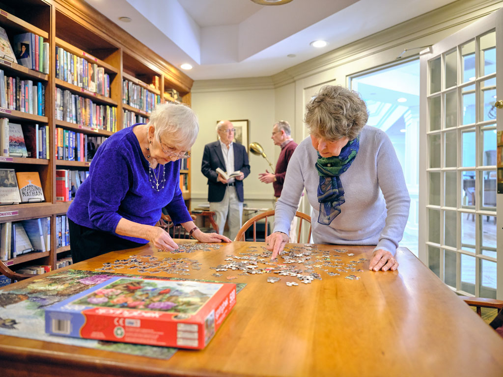 Beverwyck residents doing a puzzle in the library