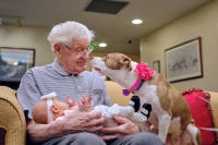 Marjorie Doyle Rockwell Center resident holding granddaughter next to dog