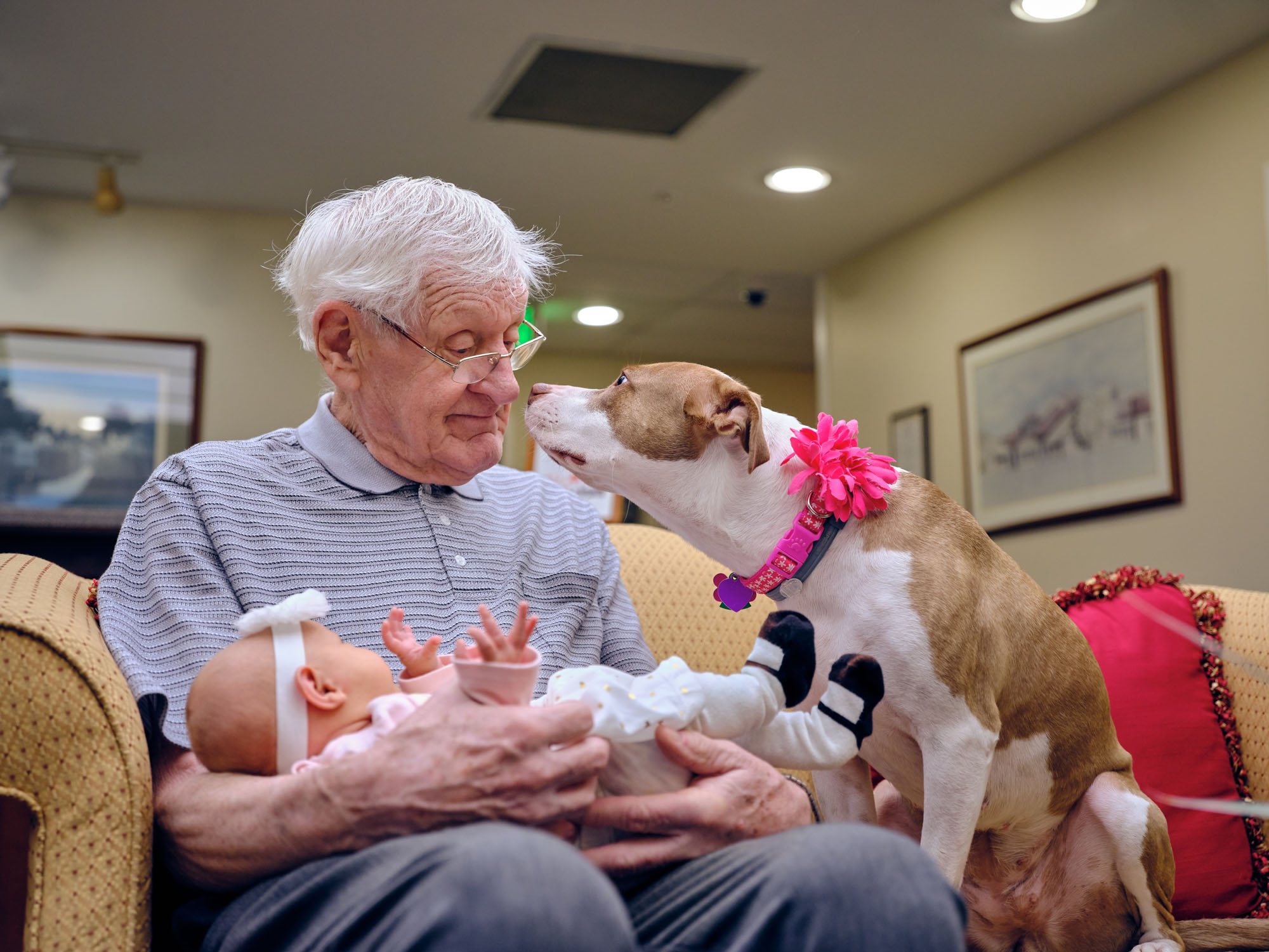 Marjorie Doyle Rockwell Center resident holding granddaughter next to dog