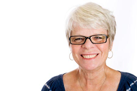 Senior woman smiling at camera, wearing glasses