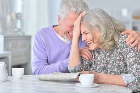 Senior couple laughing together at a table