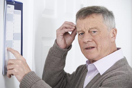 Man pointing at a calendar looking confused