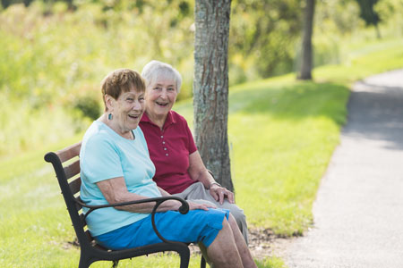 Katie and Reba smiling on a bench