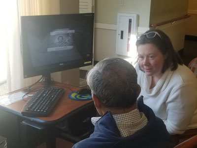 Senior man and woman at a computer listening to music