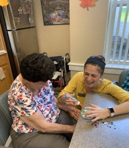 Staff and Senior Woman making a craft together