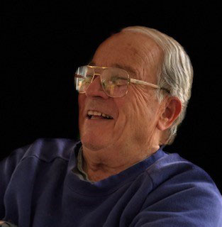 Senior man smiling with a black background