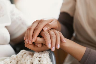 social worker holding hands of senior woman