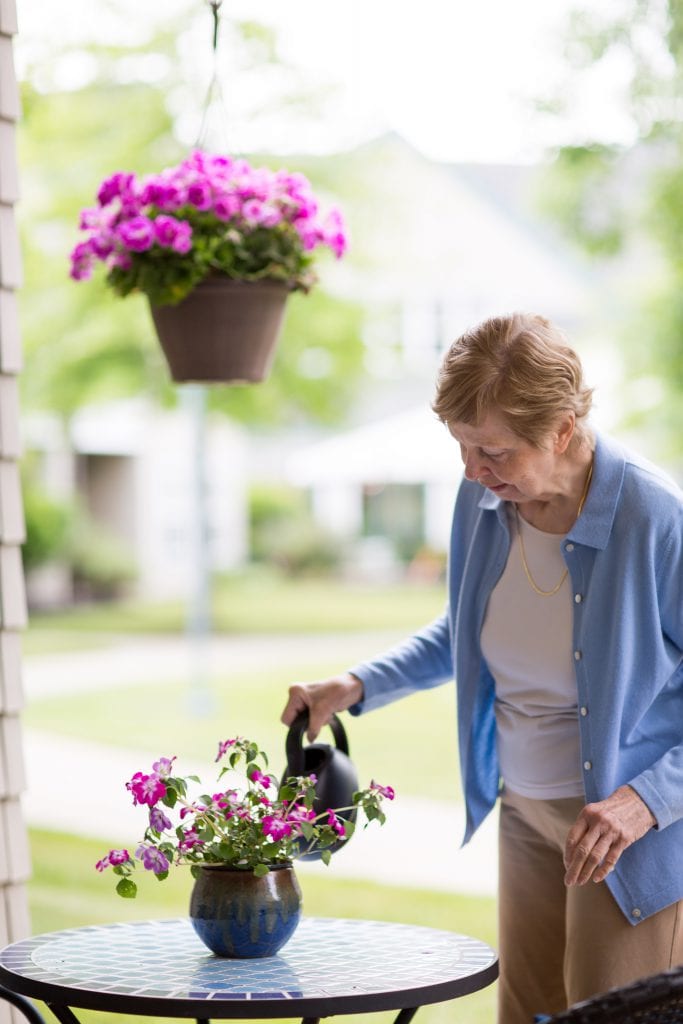 senior woman watering flowers