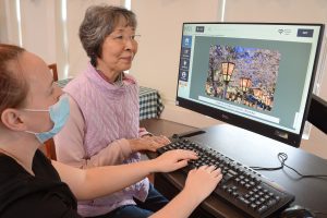 WOmen with dementia and memory care specialist working together on a computer