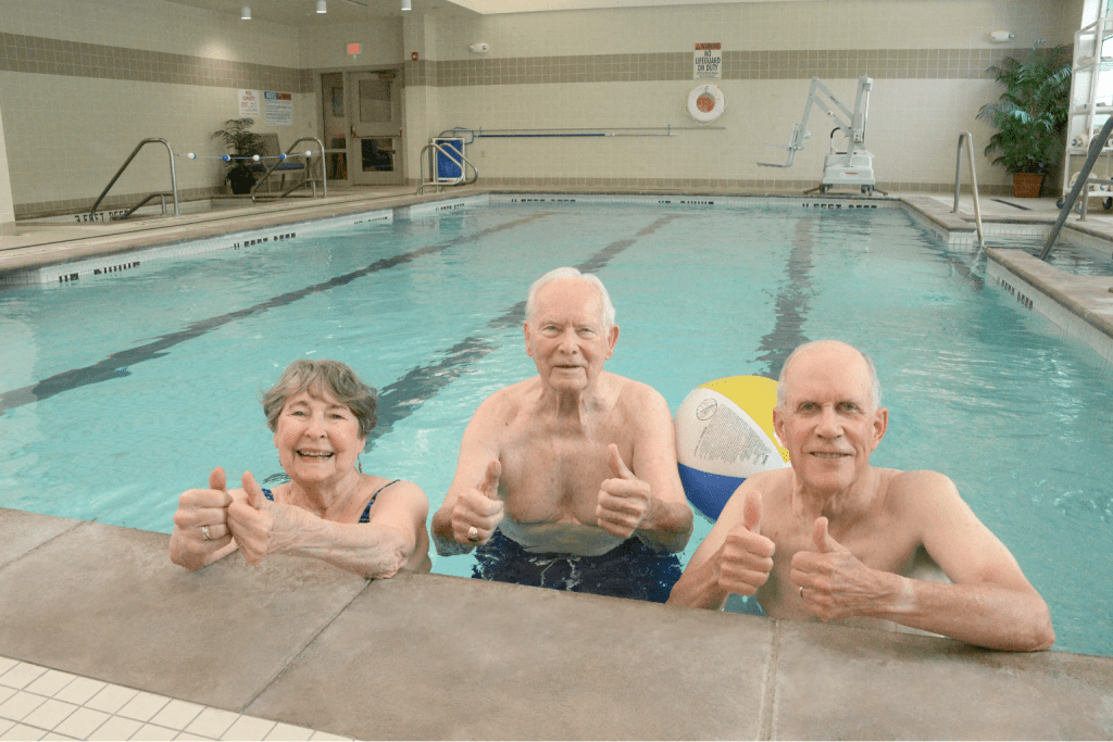 Three seniors in the pool and smiling at Eddy Senior Living